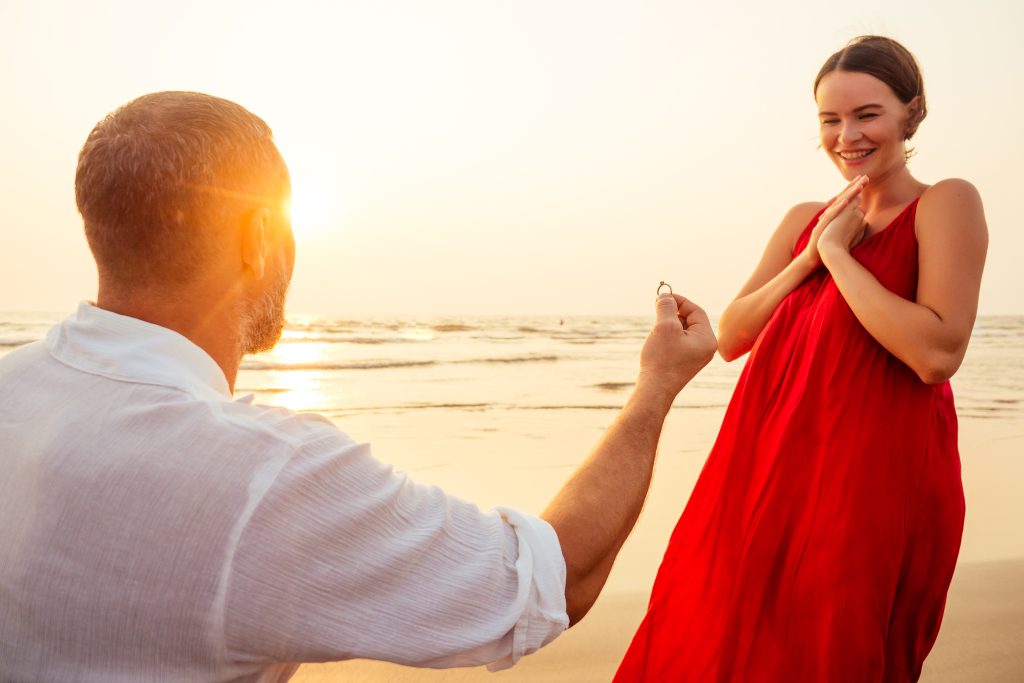 Mann macht Frau einen Antrag am Strand